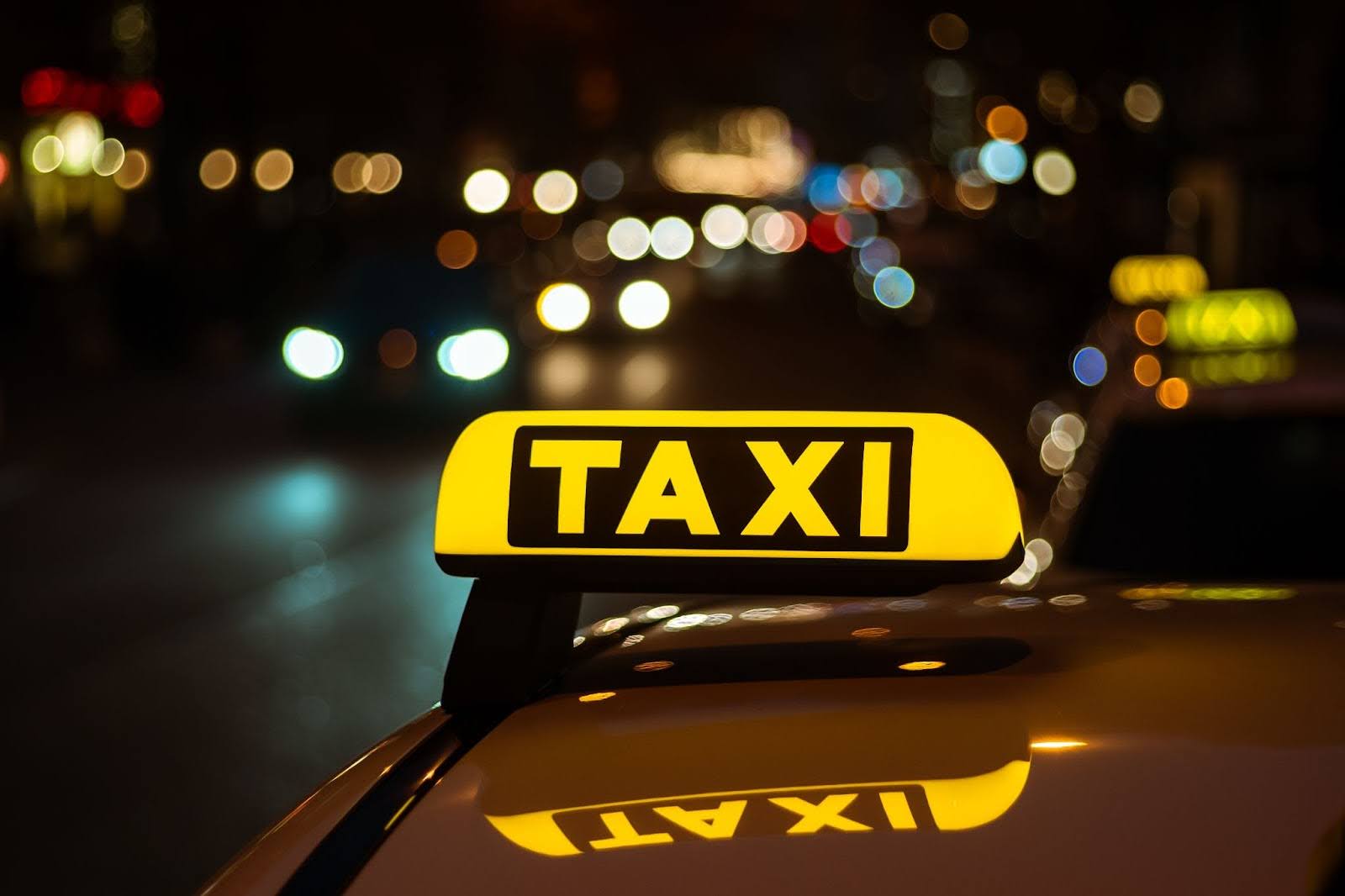 Glowing yellow taxi cab roof sign