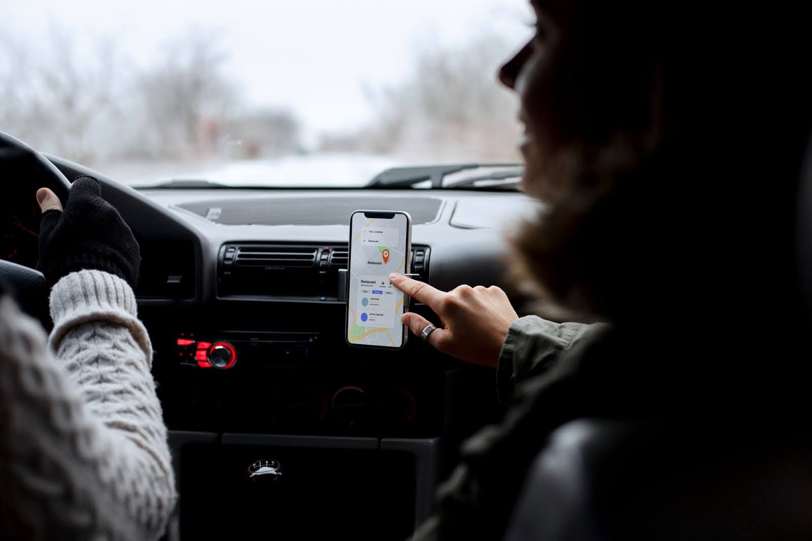 Close up of a driver and passenger utilizing a digital map app during a corporate limousine service trip